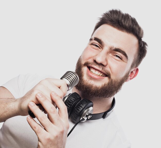 Boy Rocking Out Immagine di un bell'uomo barbuto che canta al microfono Ritratto emotivo di un bel ragazzo con la barba su sfondo bianco