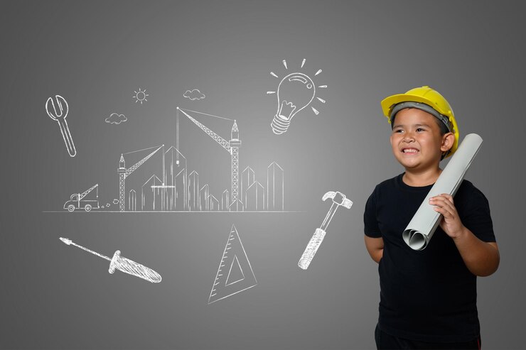 Photo boy with blueprint looking away while standing against gray background