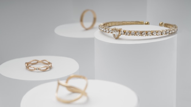 Bracciale in oro e diamanti e anelli d'oro su display bianco