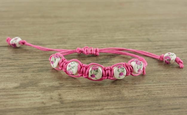 Bracciale rosa sul tavolo di legno