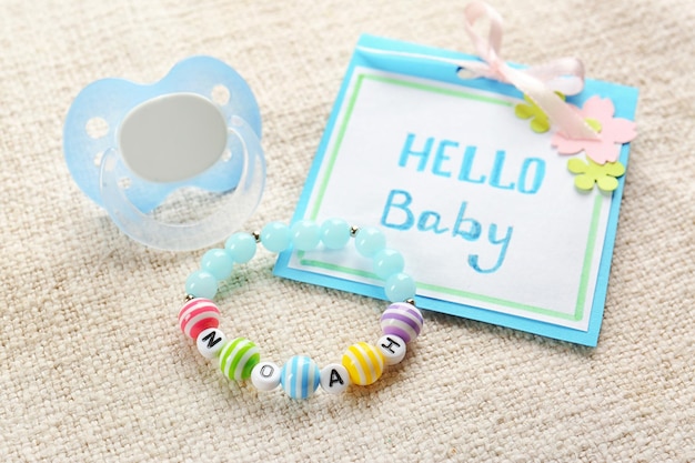 Braccialetto con il nome del bambino NOAH biglietto di auguri e ciuccio su stoffa