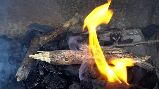 Braci che ardono nel fuoco ardente che brucia carbone vista ravvicinata