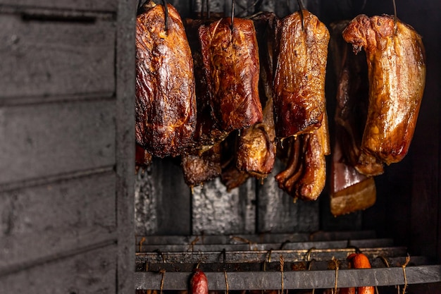 Braciola di maiale affumicata e salsicce nel concetto di cibo dell'affumicatoio