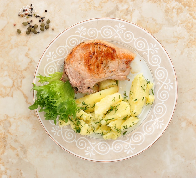 Braciola di maiale fritta con patate e insalata