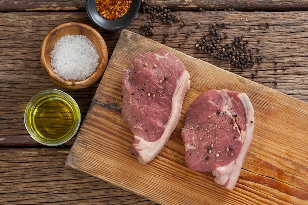 Braciole di manzo su tavola di legno con ingredienti