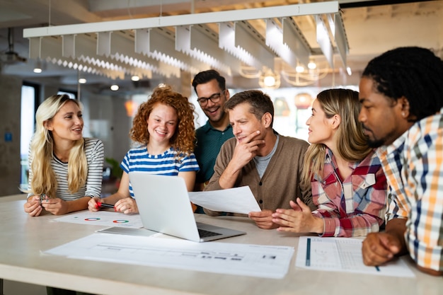 Brainstorming creativo. Felici giovani uomini d'affari, designer, architetti che lavorano come una squadra in ufficio