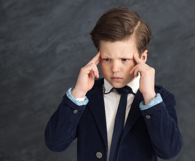 Brainstorming. Piccolo ragazzo d'affari concentrato, riflettendo su una domanda profonda, copia spazio