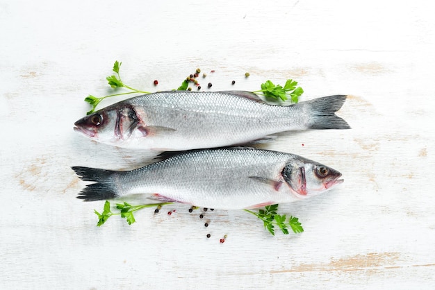 Branzino di pesce con spezie Frutti di mare su fondo di legno bianco Vista dall'alto Spazio libero per la copia