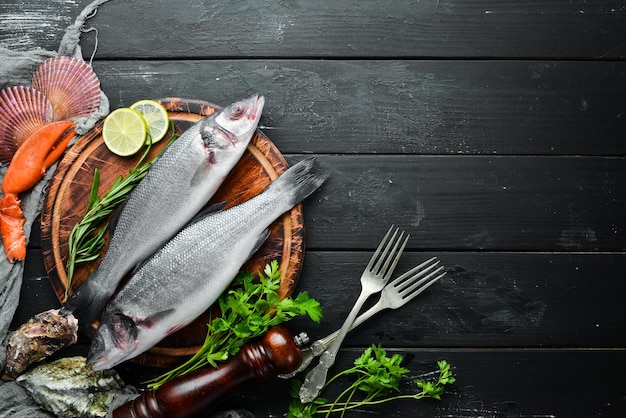 Branzino di pesce di mare Frutti di mare su sfondo di pietra nera Vista dall'alto Spazio di copia gratuito