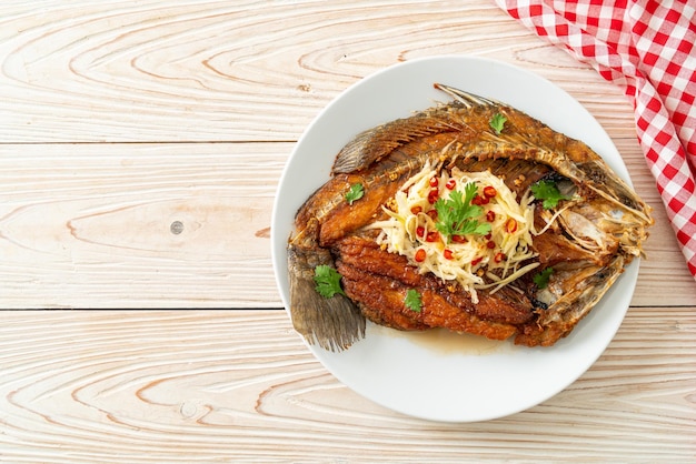 Branzino fritto con salsa di pesce e insalata piccante