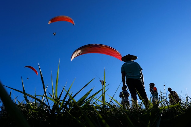 Brasile San Paolo Guaruja 09 febbraio 2019 Il parapendio sta volando nel cielo sopra le montagne e le persone lo guardanoL'area principale per il parapendio