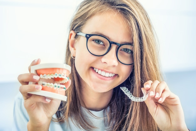 Bretelle invisibili tenute da una giovane ragazza sorridente