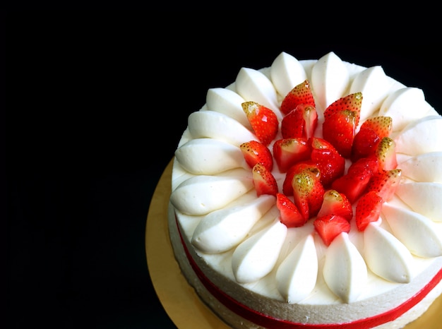 Breve torta mouthwatering della vaniglia della fragola fresca isolata su fondo nero