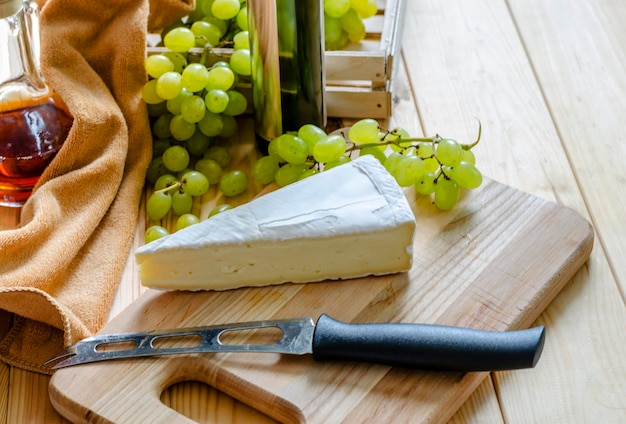 Brie e uva bianca fresca su tavola di legno