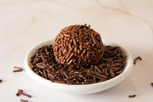 Brigadeiro palle di cioccolato brasiliane caramelle da festa con fiocchi di cioccolate vista anteriore sfondo pulito