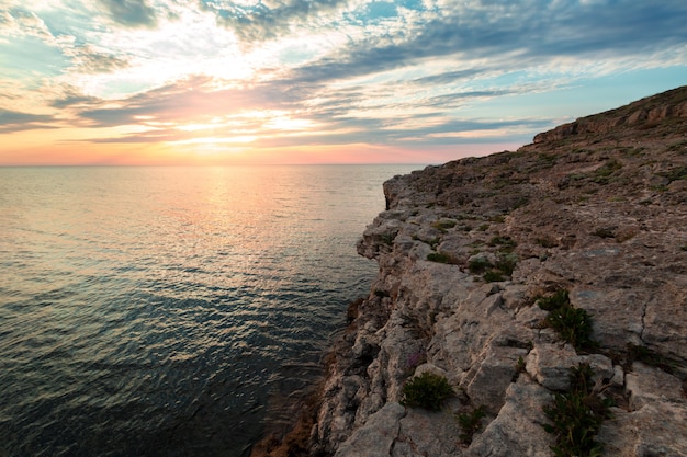 Brillante destinazione di vacanza spiaggia alba e mare scogliere sullo sfondo