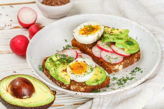 Brindare con semi di avocado, ravanello, uovo e lino