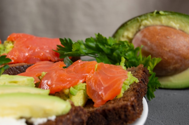 Brindate con trota di pesce rosso e purè di avocado con prezzemolo e avocado a fette