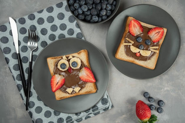 Brindisi per colazione o pranzo o merenda per bambini con crema di nocciole al cioccolato, banana, fragola e mirtillo a forma di simpatico gufo e orso. Menù cibo per bambini