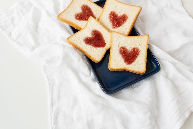 Brindisi su cui il cuore è fatto di marmellata Concetto di colazione a sorpresa a letto Romanticismo per il giorno di San Valentino un posto per un'iscrizione