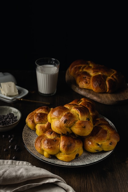 Brioche al forno fresca con gocce di cioccolato su fondo di legno scuro