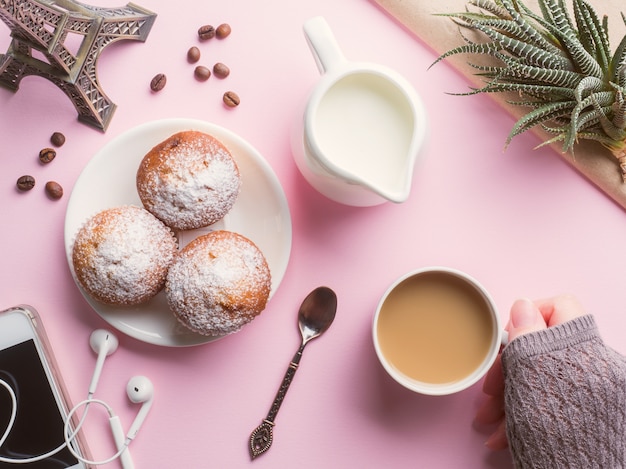 Brocca di latte del caffè dei muffin della prima colazione su un fondo rosa. Vista dall&#39;alto Piatto posare.