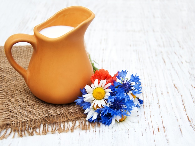 Brocca di latte e fiori di campo