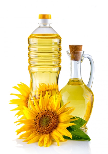 Brocca e bottiglia di olio di girasole con fiore isolato su bianco