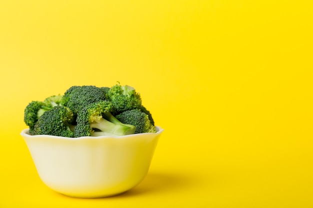 Broccoli di broccoli verdi freschi in una ciotola su sfondo colorato. , avvicinamento. Verdura fresca