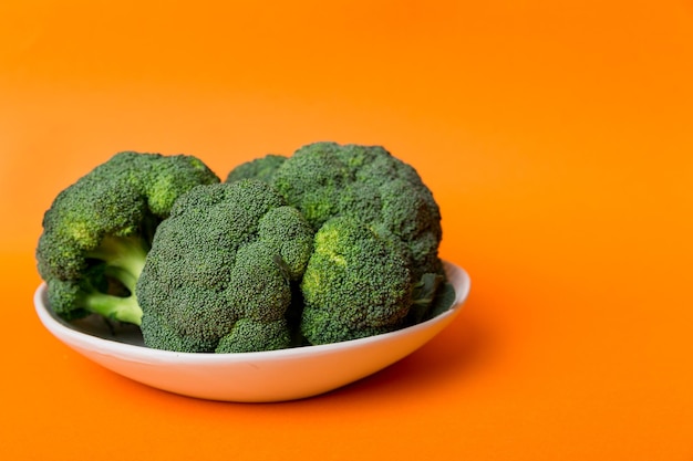 Broccoli di broccoli verdi freschi in una ciotola su sfondo colorato. , avvicinamento. Verdura fresca.