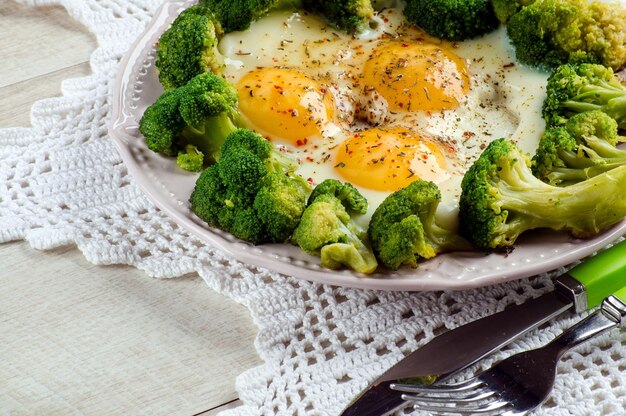 Broccoli e uova cotti su un piatto su un tavolo luminoso