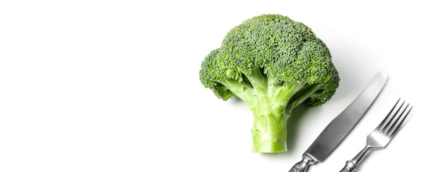 Broccoli ecologici freschi contro bianco con forchetta e coltello