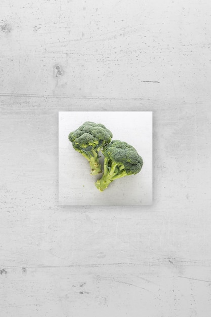 Broccoli freschi di vista dall'alto su fondo di cemento bianco.