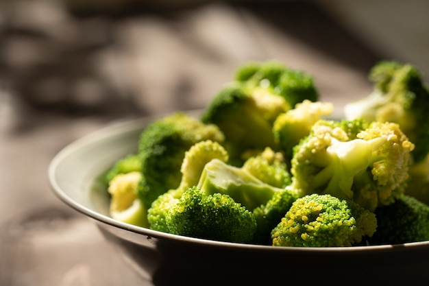 Broccoli in un piatto sotto i raggi del sole