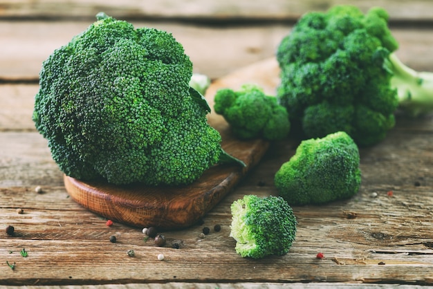 Broccoli organici freschi sulla fine di legno della tavola su