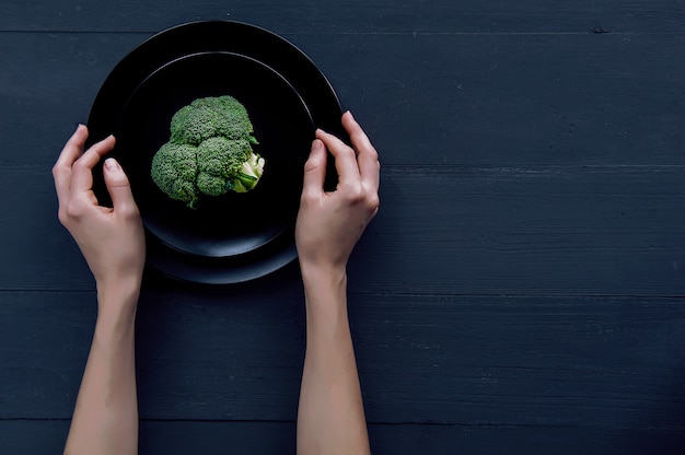 Broccoli su una banda nera su una superficie di legno nera