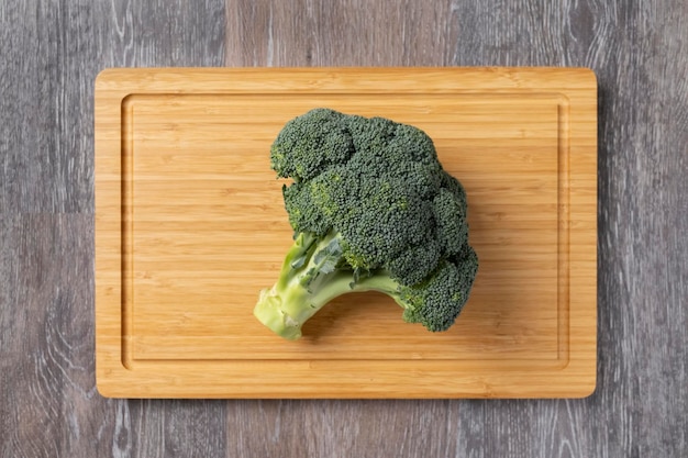 Broccoli verdi freschi sul tagliere di legno. Broccoli foglie di cavolo sfondo chiaro Posa piatta