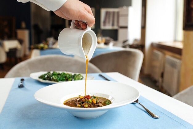 Brodo di colata nel piatto con zuppa di coda di bue