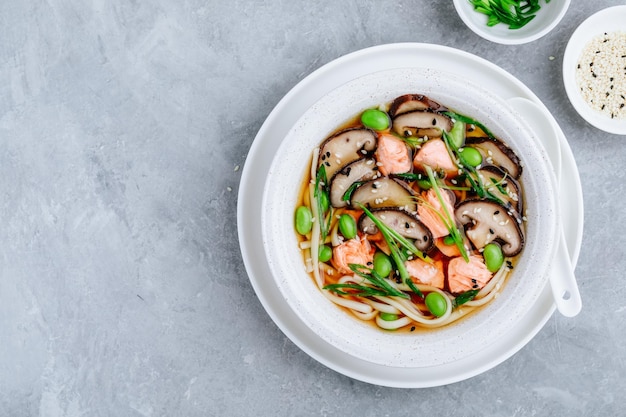 Brodo di salmone e soba Zuppa di noodle al salmone con funghi shiitake fagioli edamame e cipolla verde