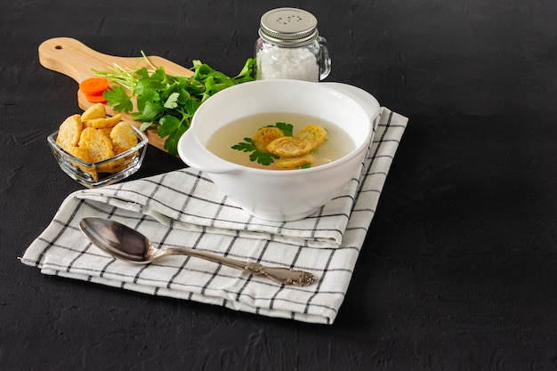 Brodo o brodo di pollo fatto in casa. colazione salutare. sfondo nero cemento