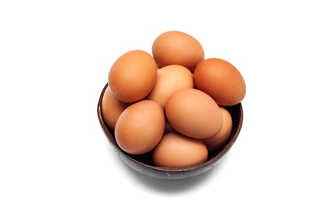 Brown uova di gallina crude in una tazza su uno sfondo bianco. Sfondo di cibo.