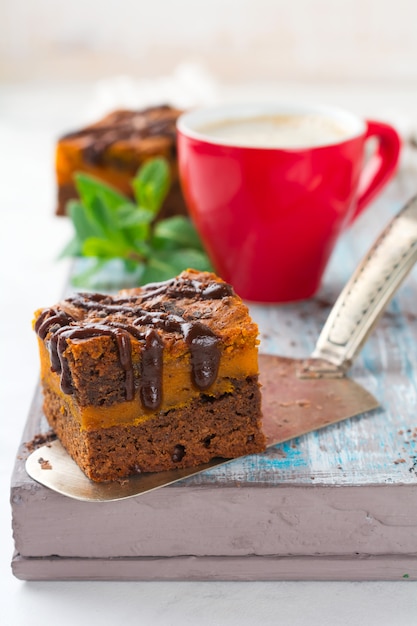 Brownie al cioccolato con una zucca su uno sfondo chiaro. Messa a fuoco selettiva.