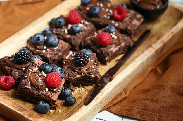 Brownie con frutti di bosco e cioccolato su una tavola di legno Brownies vegani fatti in casa