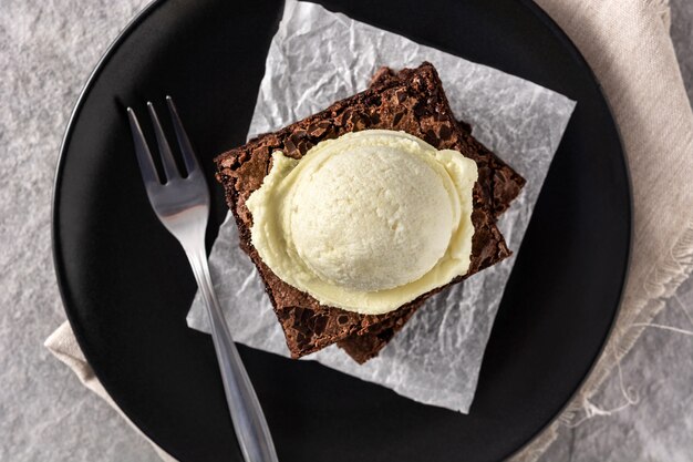 Brownie con gelato alla vaniglia scoop sul tavolo di pietra grigia