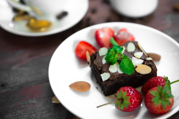 Brownie con la fragola fresca sul piatto bianco