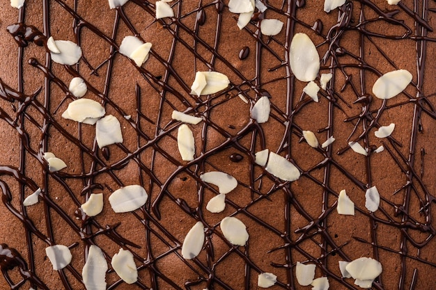 Brownie con petali di cioccolato e mandorle primo piano sullo sfondo dell'alimento