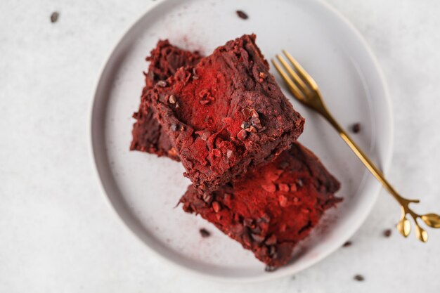 Brownie di barbabietola sul piatto grigio, copia spazio. Cibo vegano sano.