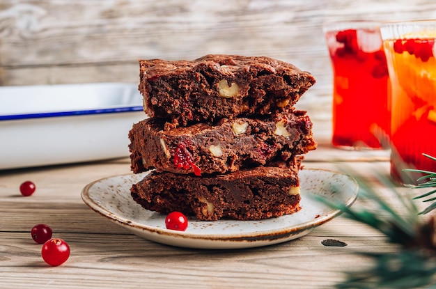 Brownies di Natale con noci e mirtilli rossi su fondo di legno rustico Rami di abete e decorazioni natalizie