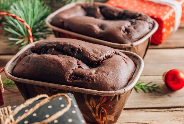 Brownies di torta al cioccolato per un regalo su un tagliere di legno con decorazioni natalizie su fondo rustico. Messa a fuoco selettiva