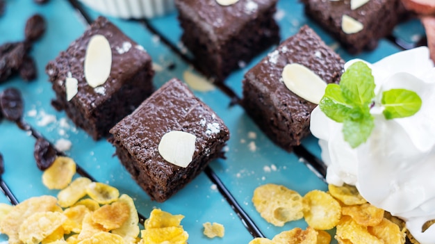 Brownies e panna montata su un piatto blu.